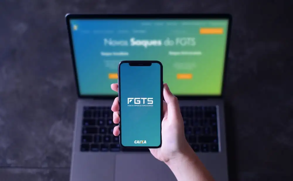 Computador e celular com aplicativo FGTS